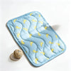Light blue quilted pet mat featuring a repeating pattern of yellow curved shapes for dogs and cats