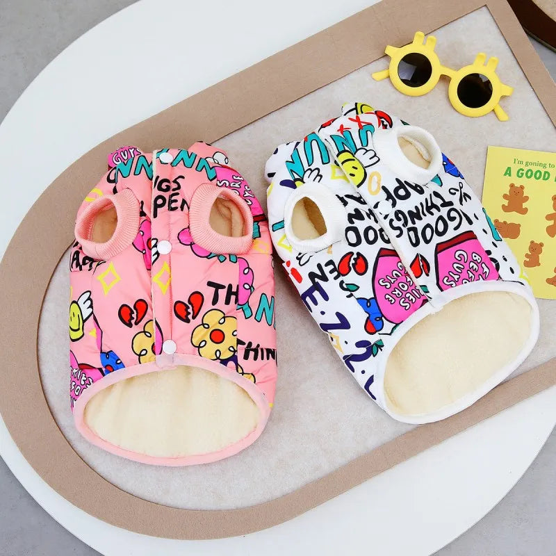 A pink and white waterproof winter dog coat with a yellow sunglasses accessory displayed on a neutral background.