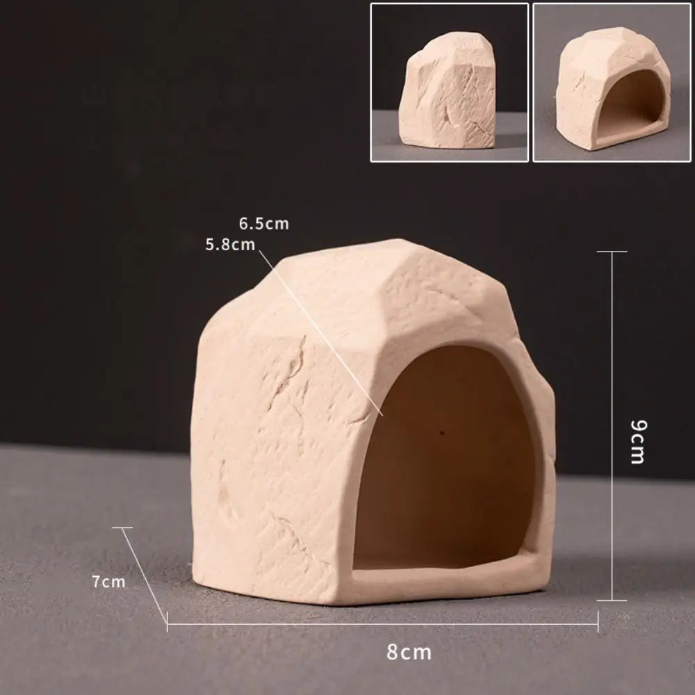 A light beige ceramic aquarium shrimp hideaway cave with an entrance, shown from the side and top views.