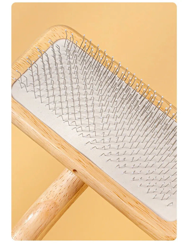 A wooden pet grooming brush with massage bristles shown at an angle.