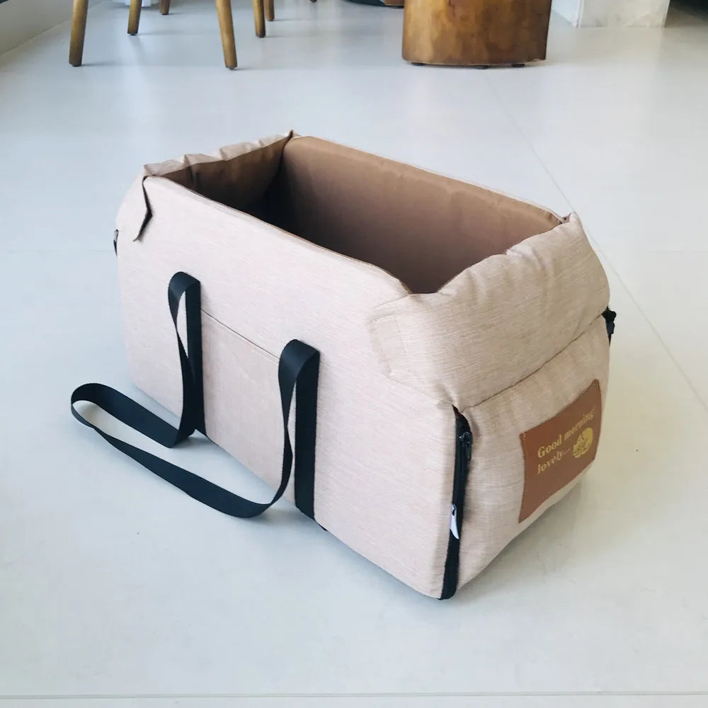 Beige tragbare Hundesitzbank mit schwarzen Gurten auf weißem Boden.