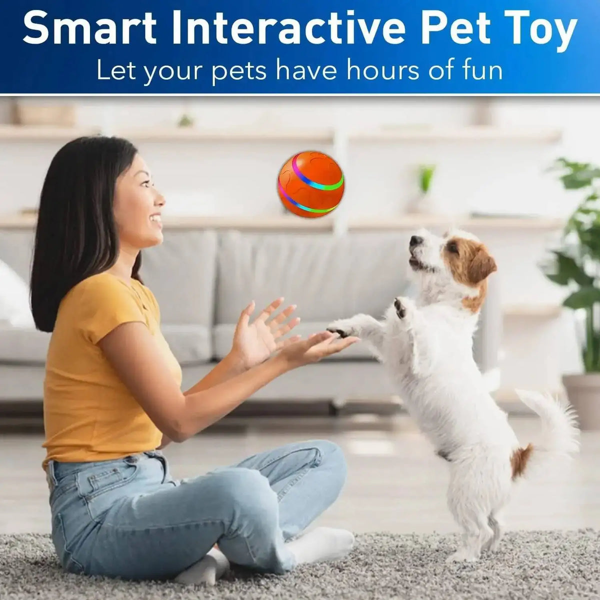 A woman is playing with a white dog and an orange pet ball, demonstrating a smart interactive pet toy.