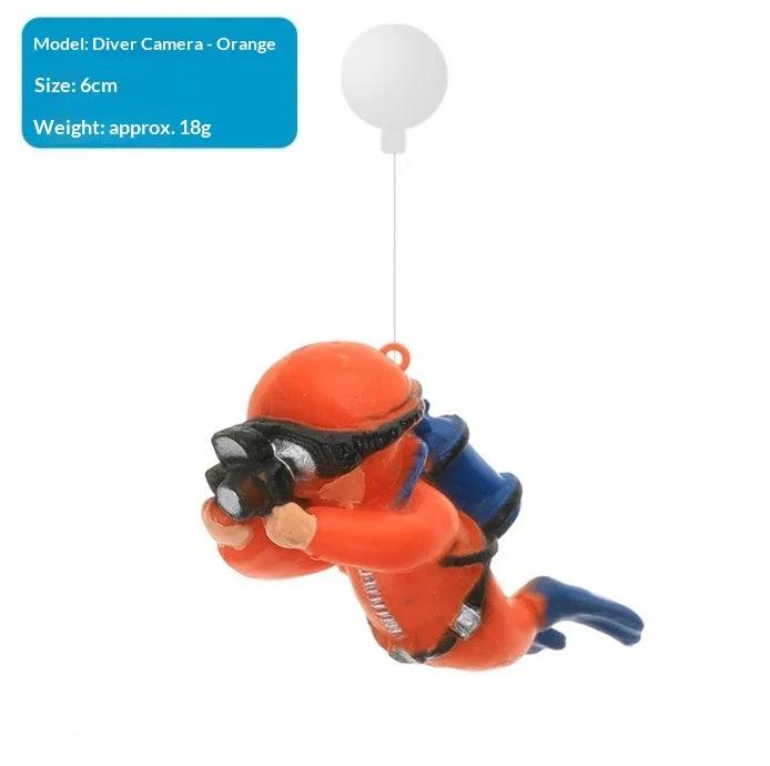 An orange diver aquarium ornament is suspended by a thin wire.