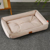 A beige luxurious corduroy pet sofa bed for dogs and cats resting on a gray carpet.
