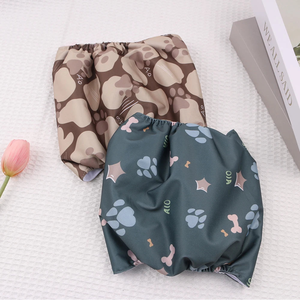 A pair of reusable dog belly bands in brown and beige camouflage patterns lying on a white surface.