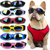 A collection of colorful collapsible dog sunglasses with adjustable straps shown against a white background.
