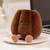 A fluffy brown dessert plush toy sitting on a white plate.