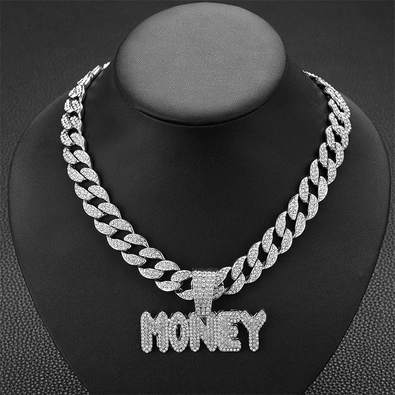 A silver iced out letter and animal pendant Cuban link chain necklace displayed on a black display stand.