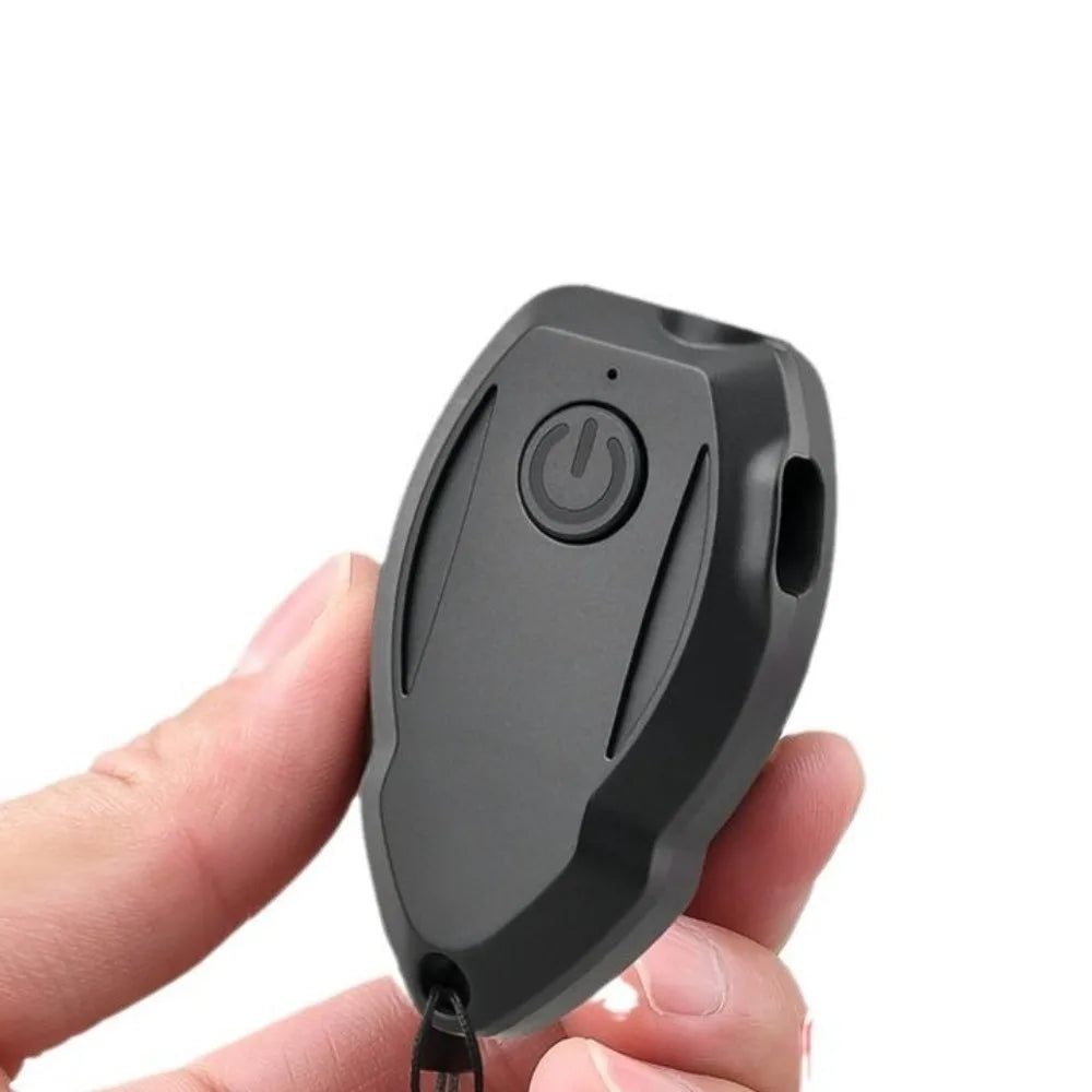A hand is holding a black handheld ultrasonic dog bark deterrent device with an LED light.