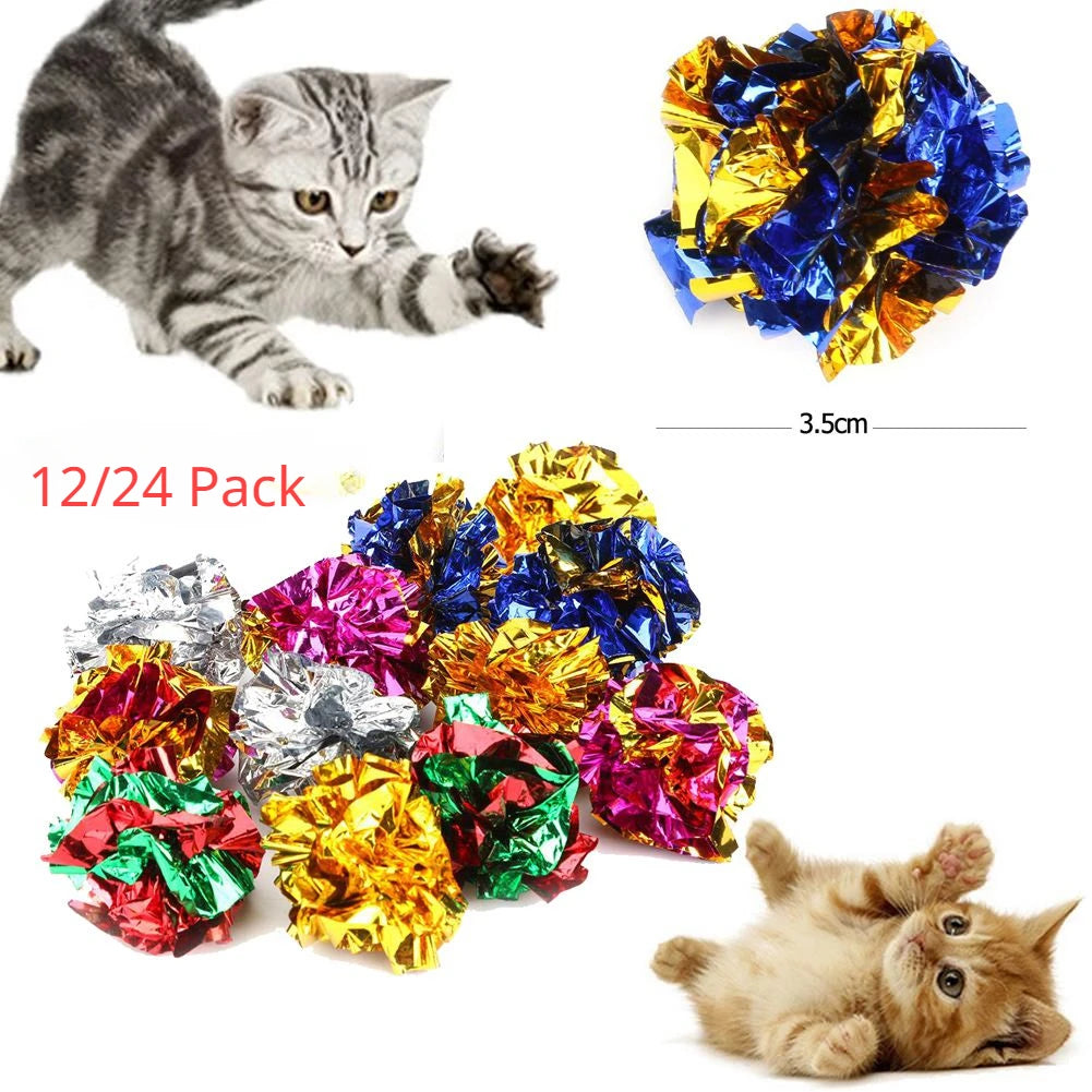 A collection of colorful crinkle balls and cat toys with a kitten resting nearby.