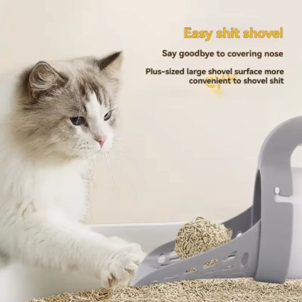 A fluffy gray and white cat is using a plus-sized large shovel to scoop litter from a tray.