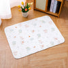 A white soft cotton pet cage mat with a non-slip base placed on a light wood floor.