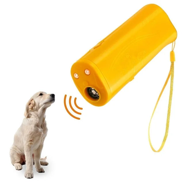 Entraîneur canin ultrasonique et lampe de poche jaune avec sangle jaune, à côté d'un chien de couleur claire.