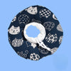A dark blue fabric collar with a repeating pattern of white cat faces and paw prints, featuring a white adjustable loop.