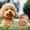 Ein flauschiger Golden Doodle Hund liegt auf grünem Gras neben einer Holzschatztruhe mit geprägten Pfotenabdrücken.