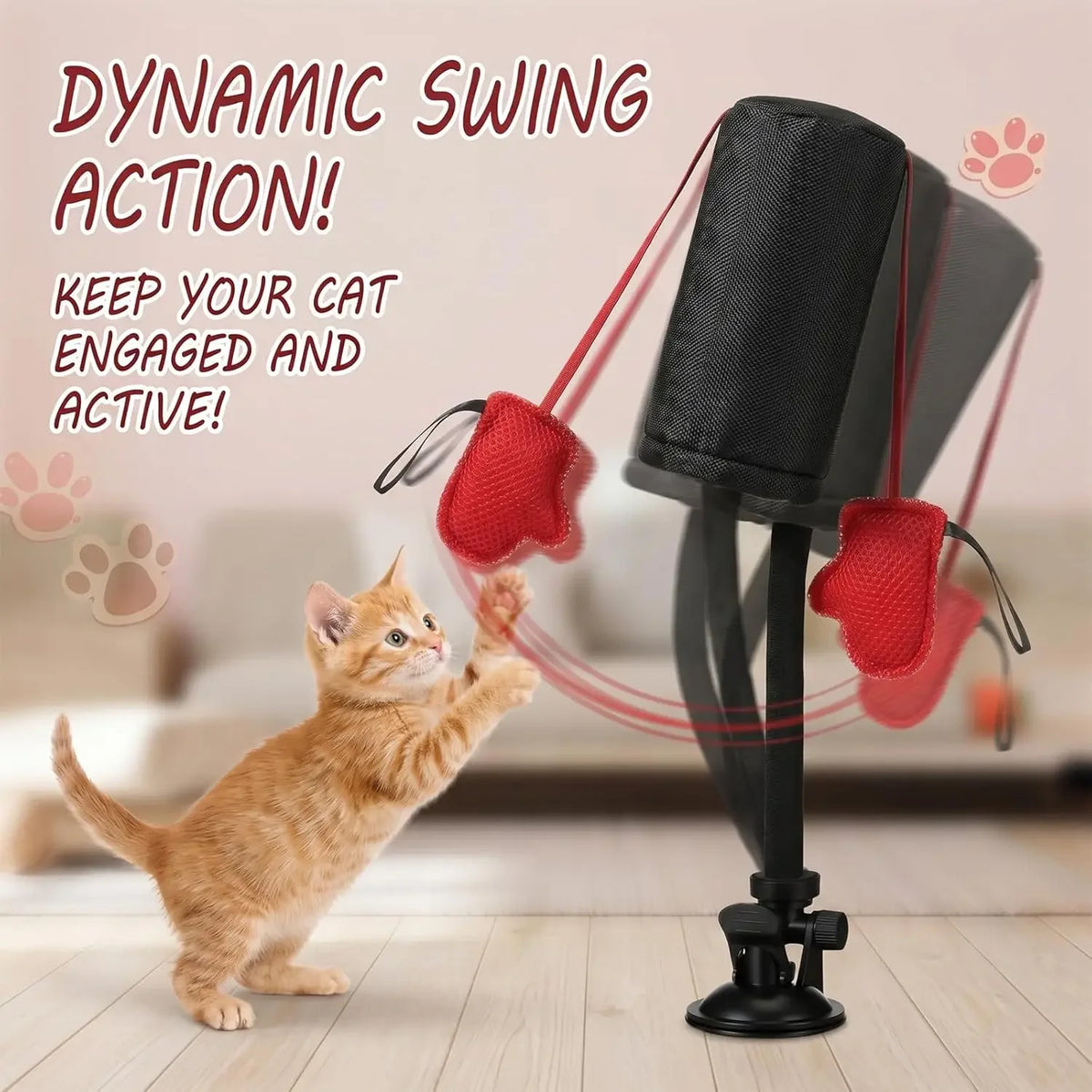 An orange kitten is swinging on a dynamic cat swing toy with red boxing gloves and a black base.