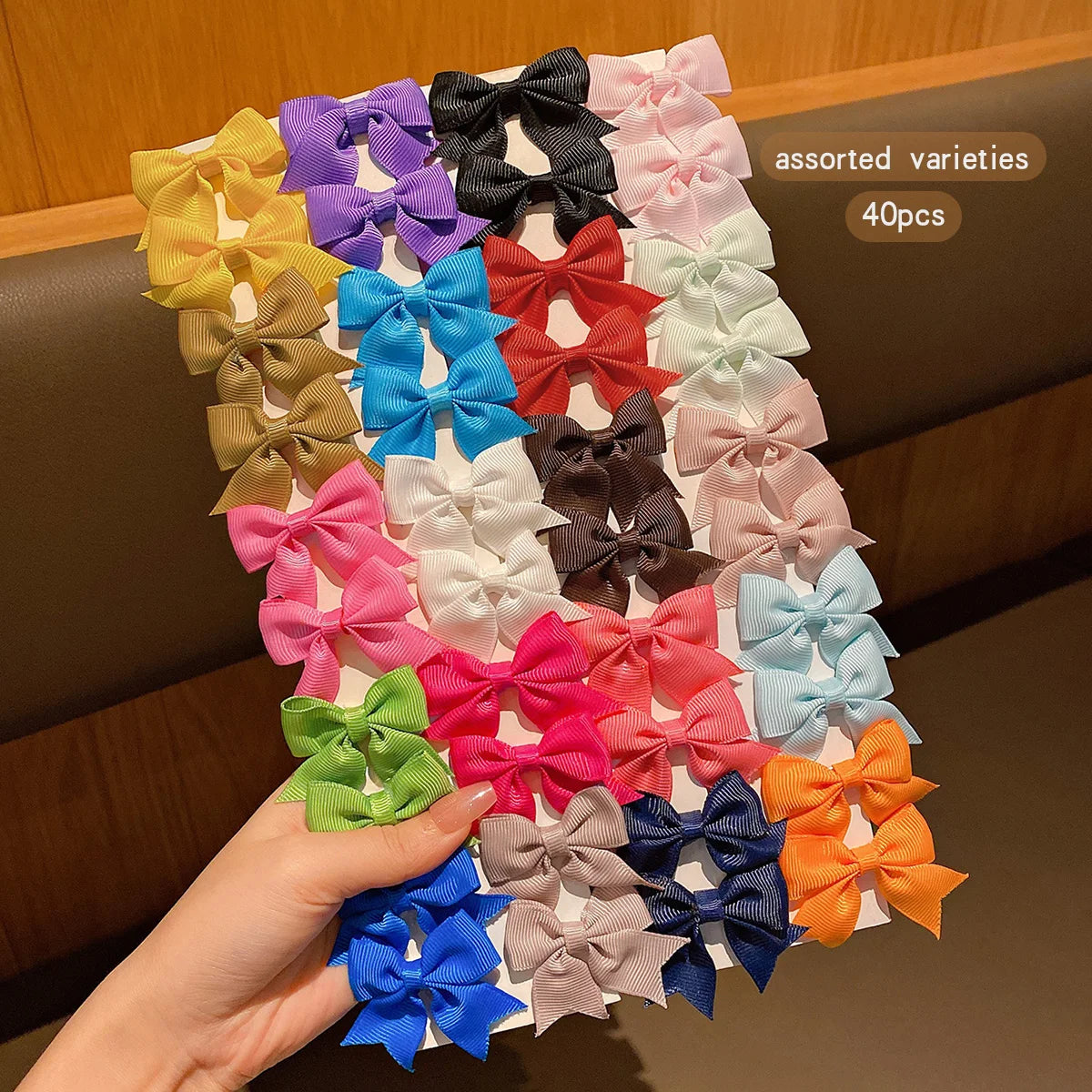 Assorted varieties of colorful fabric hair bows and clips in various shades of pink, blue, yellow, green, and black.