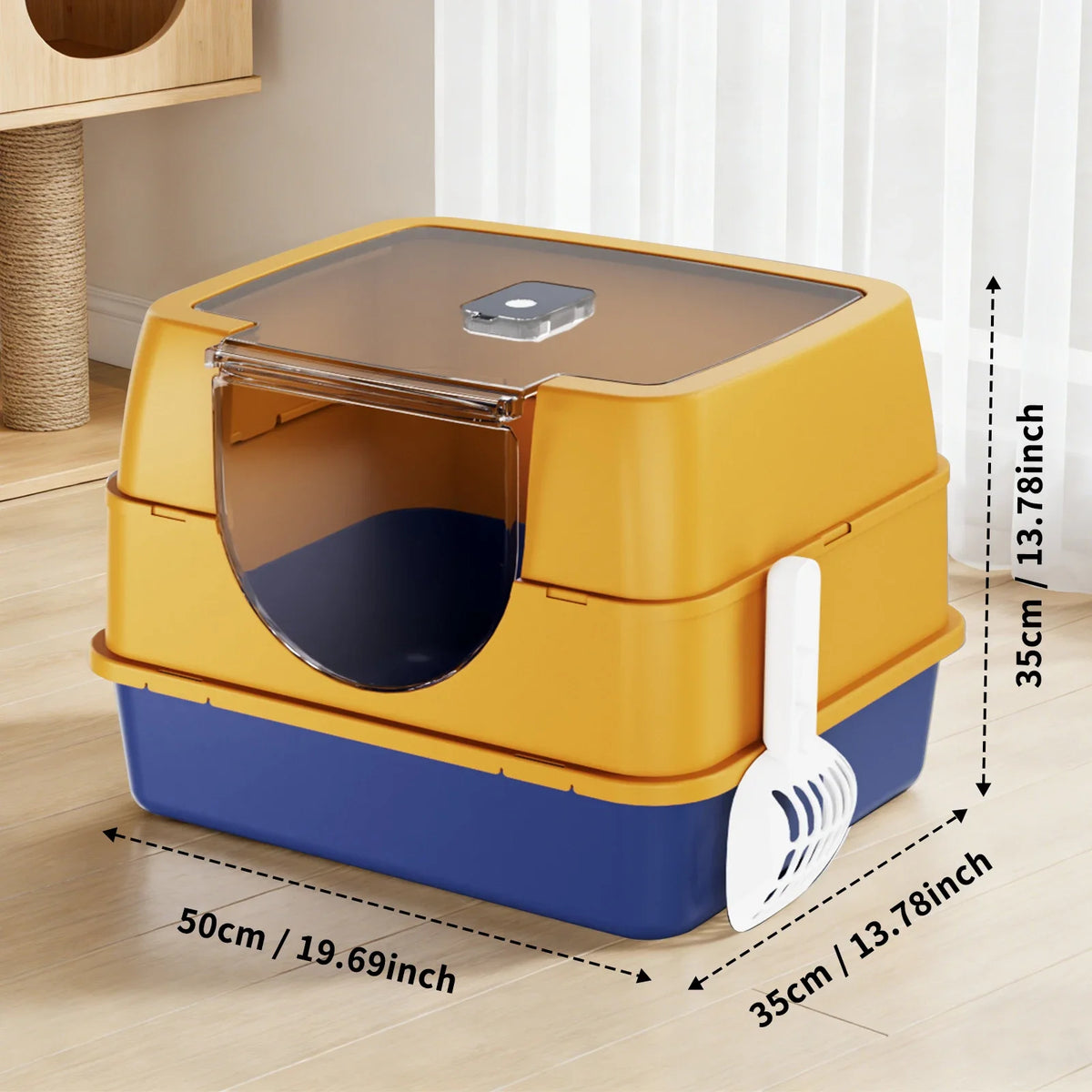 A yellow and blue enclosed stainless steel cat litter box with a transparent lid and a white scoop shown on a wooden floor.