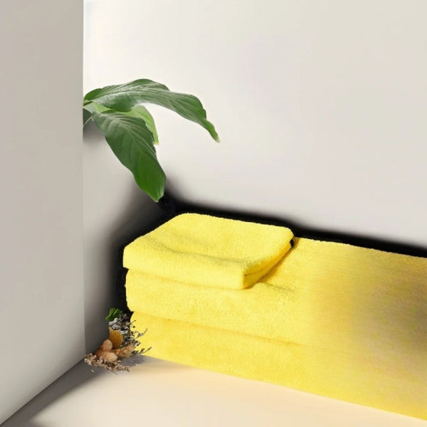 A stack of bright yellow ultra-absorbent pet drying towels resting on a white surface.