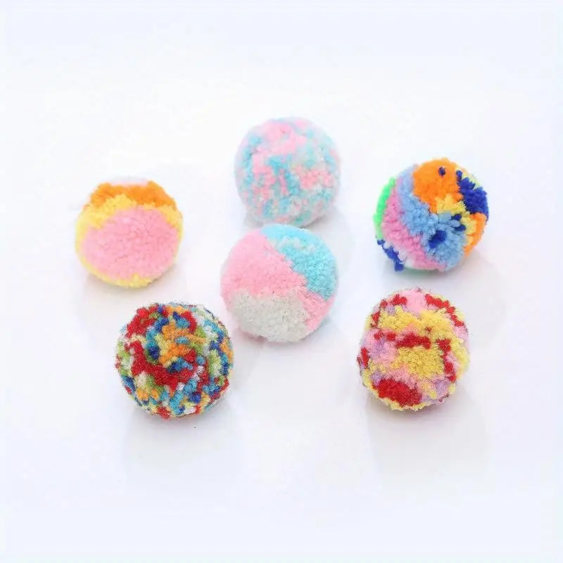 A collection of six colorful plush wool balls in various shades of pink, blue, yellow, and orange.
