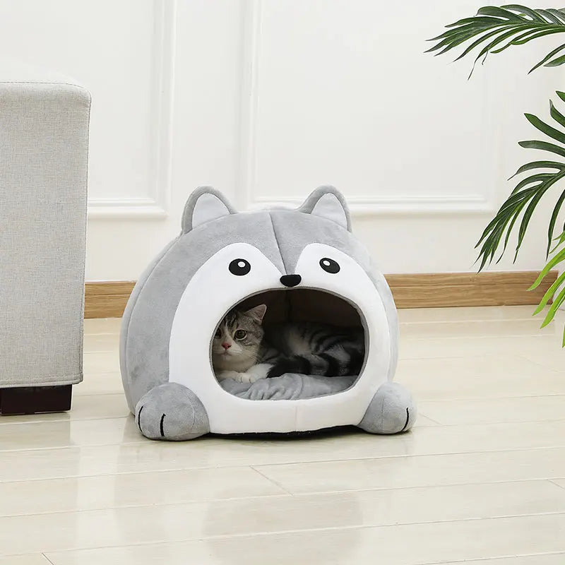 Un lit de sourice gris et moelleux avec une entrée où un petit chaton tigré se repose.