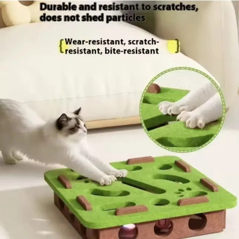 A green felt cat puzzle maze with wooden pieces and a bell ball is shown on a white surface.
