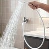A hand is operating a white 360° portable faucet sprayer with a long hose, directing a strong stream of water into a sink.