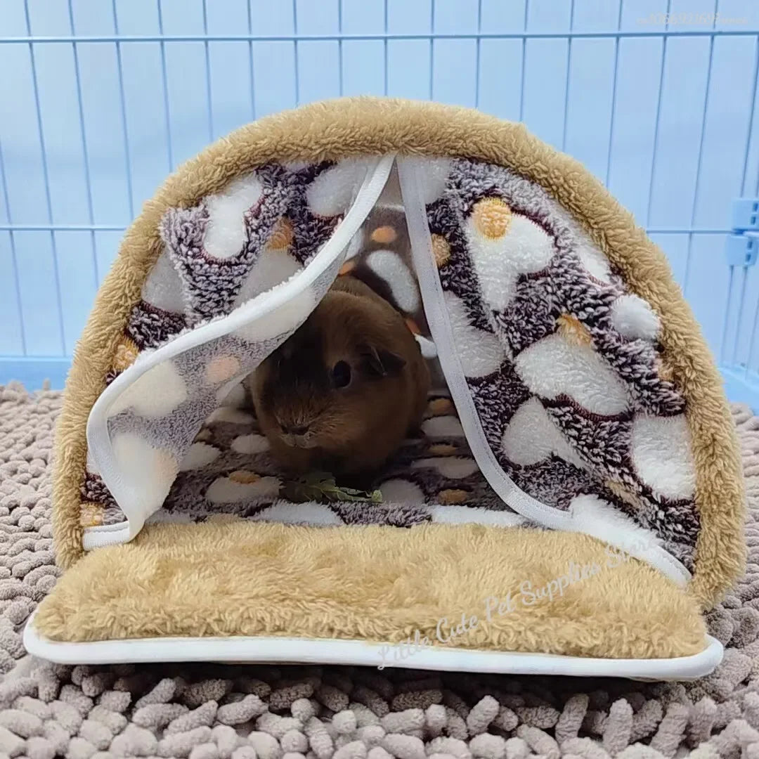 Hamaca de mascota beige y esponjosa con interior estampado y ribete blanco, sobre una superficie texturizada.
