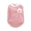 A soft pink pet vest with a white embroidered face design.