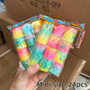 A hand holds a clear plastic package containing 24 colorful spring coil toys in various shades of yellow, pink, and blue.