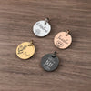Three personalized stainless steel pet ID tags engraved with names Winston Sundae and Beay resting on a wooden surface.