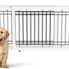 A white adjustable wooden pet gate with black bars, featuring a golden-colored dog sitting in front of it.