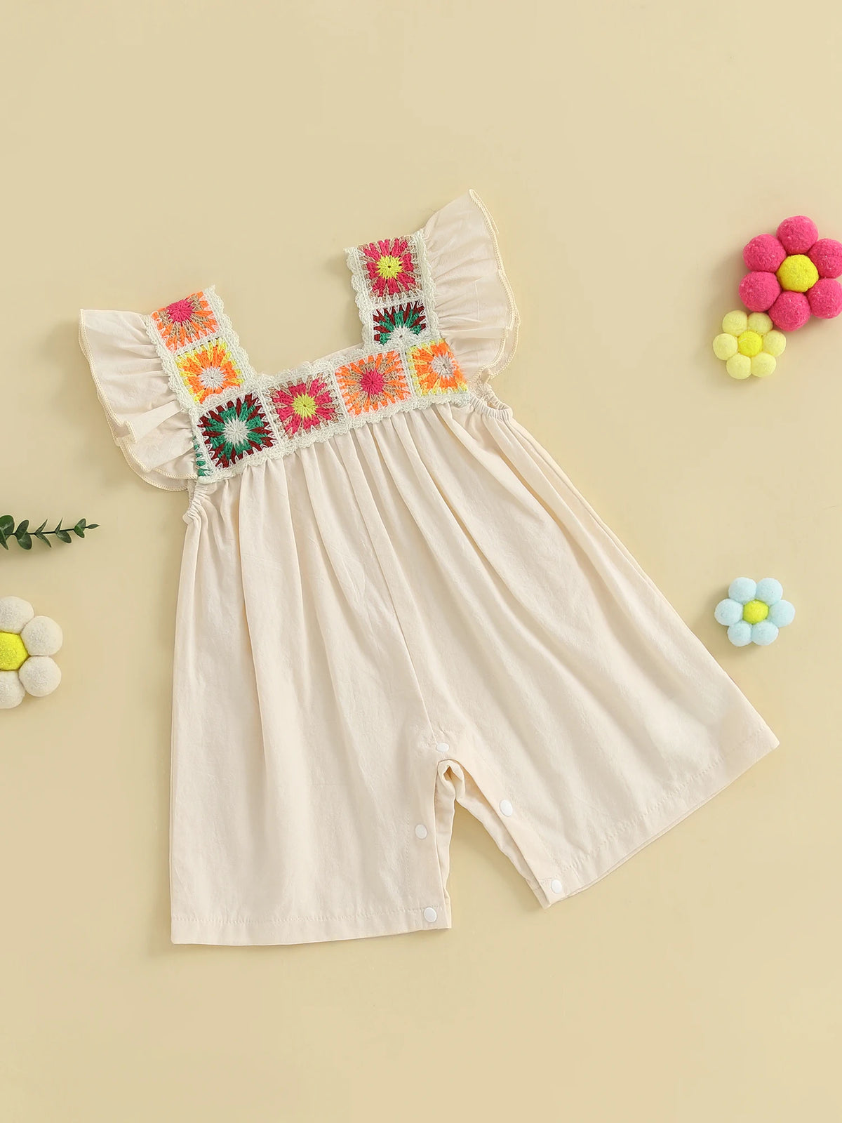 A cream-colored floral embroidery toddler romper for girls with pink and yellow accents.
