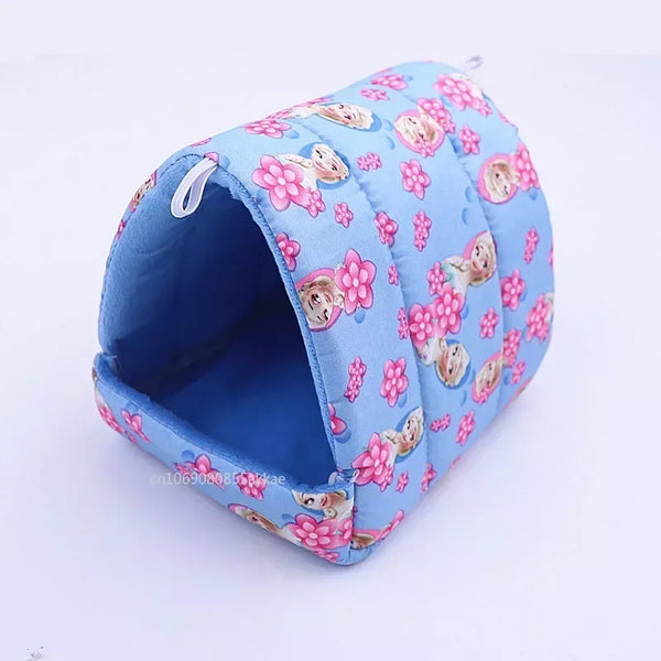 A light blue fabric hamster house bed decorated with pink floral cartoon patterns.