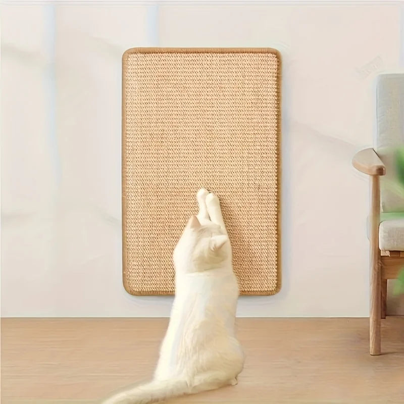 Un chat blanc est positionné devant un pote de grattage rectangulaire en sisal sur un plancher en bois.