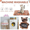 A fluffy cat is resting on a orange pet mat and sleeping pad, with laundry care icons nearby.