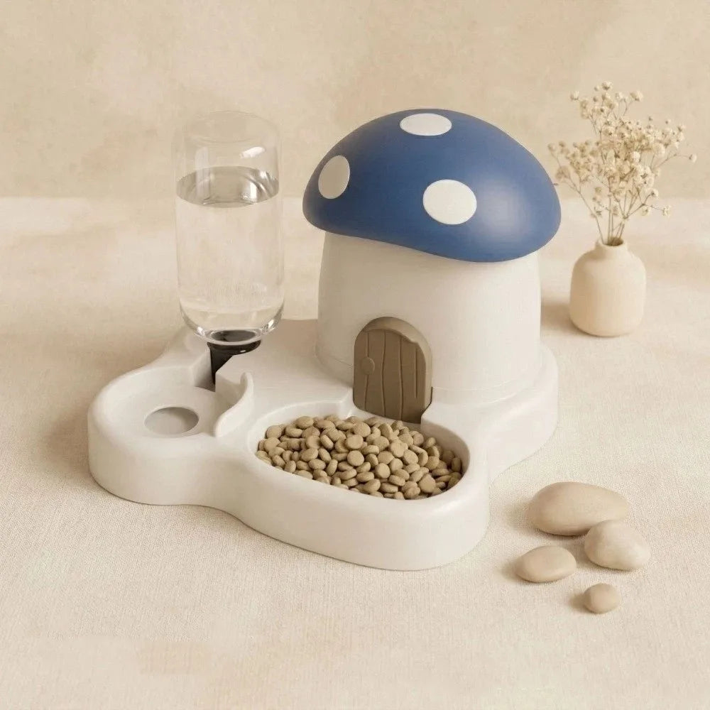 A white mushroom-shaped feeder and water dispenser with a blue cap, next to a glass of water and some pebbles.