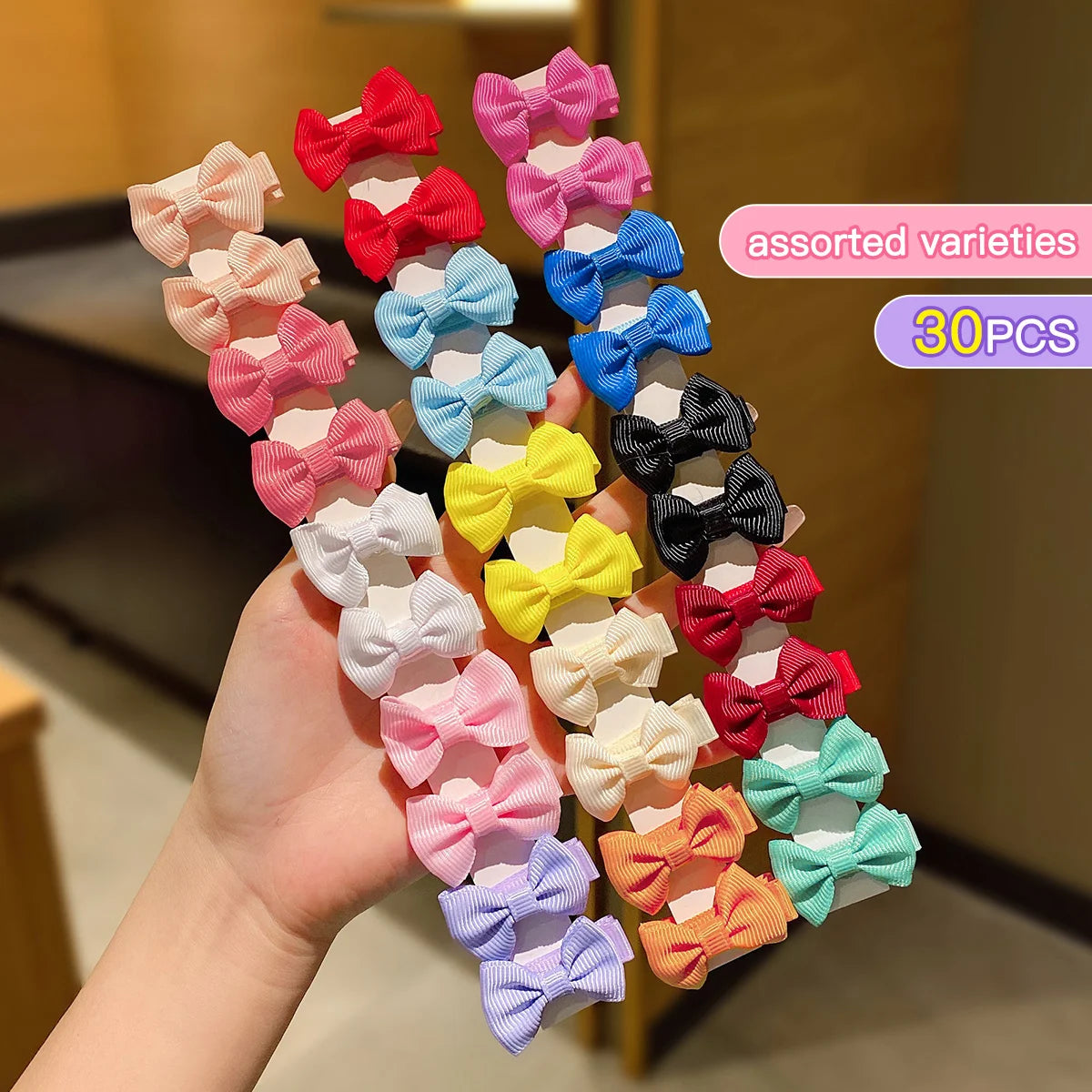Assorted varieties of colorful fabric hair clips in various shades of pink, red, blue, and yellow