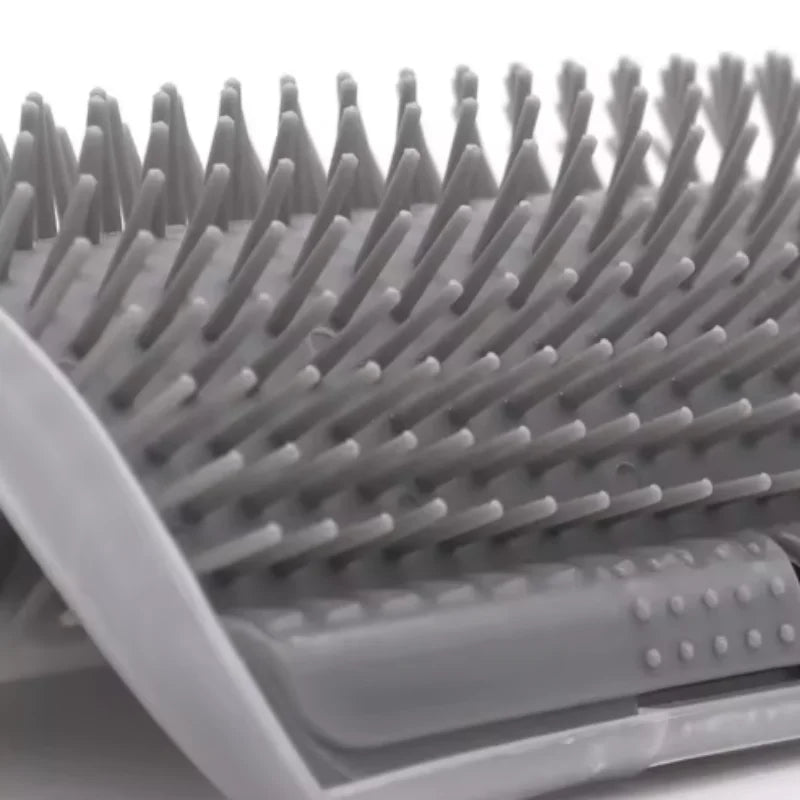 A close-up view of a gray self-grooming cat brush with numerous fine bristles and a corner mount.