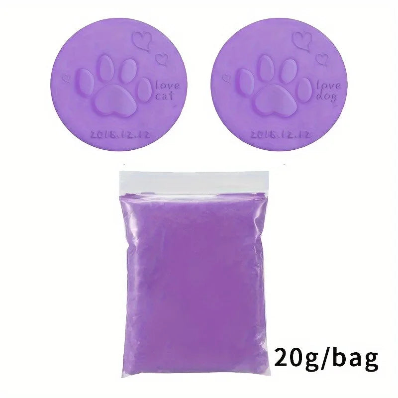 Purple clay paw prints with 'love cat' and 'love dog' text on a circular mold, next to a bag of purple clay.