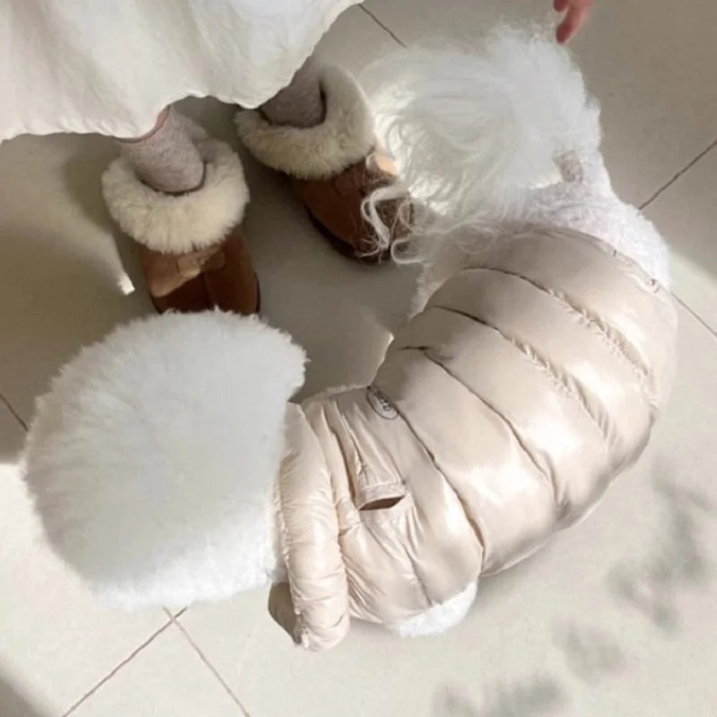 Weiches Winterfell für Hunde und Katzen mit weißem Kunstfellbesatz an einem beigen gepolsterten Kleidungsstück.