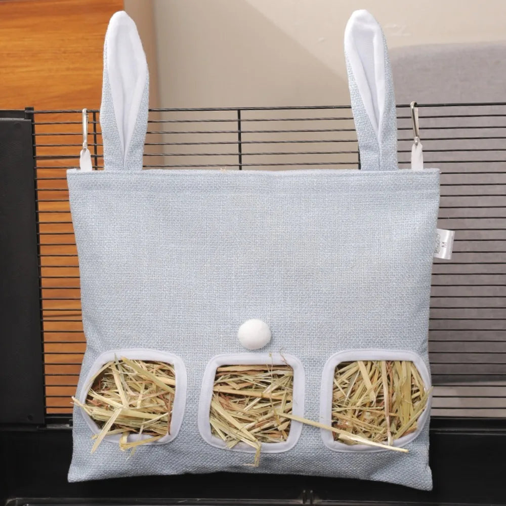 A light blue fabric bag with multiple holes designed as a hay feeder for small animals.