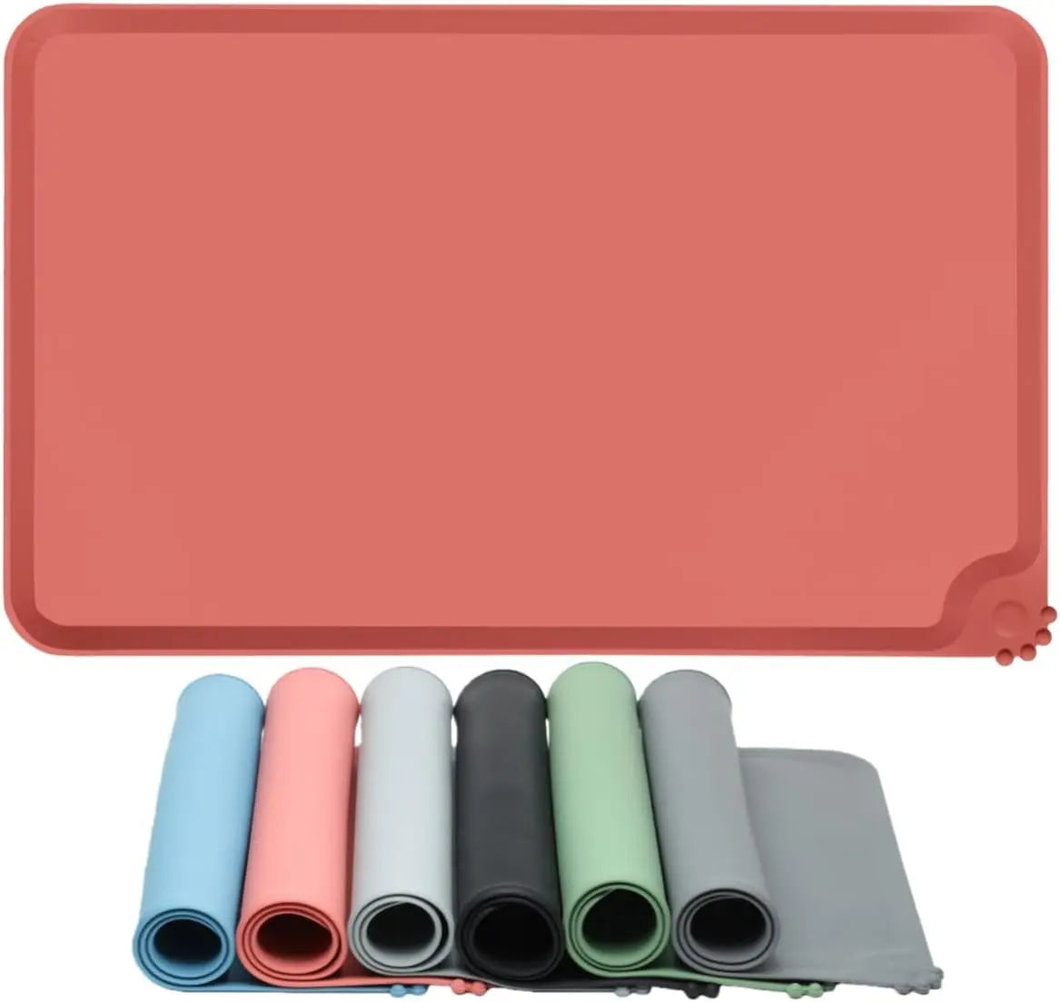 A set of waterproof silicone pet feeding mats in various colors and shades, including blue, pink, gray, and green.