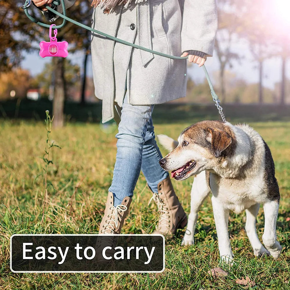 A person is walking a dog on a leash, demonstrating the easy to carry reusable pet poop bag dispenser.