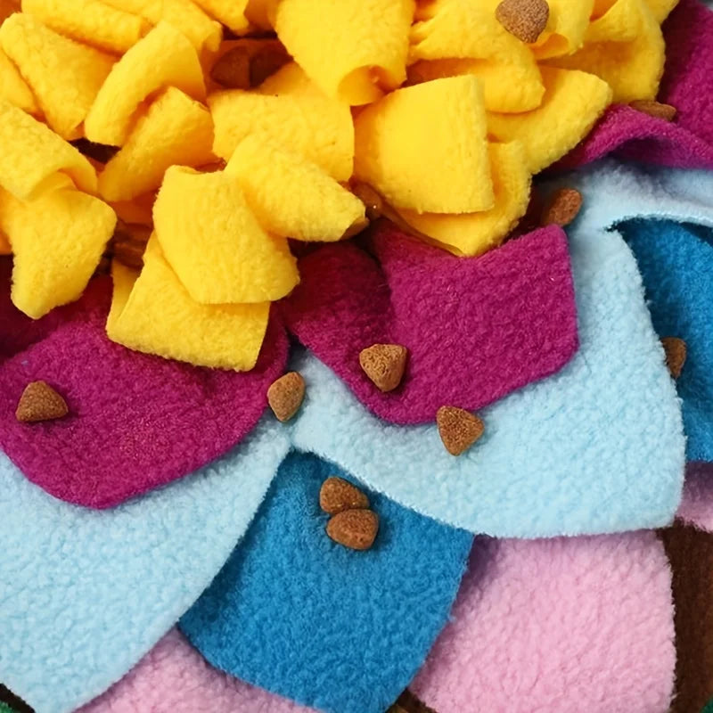 A close-up of a colorful, textured mat with yellow, purple, and blue felt pieces for interactive sniffing.