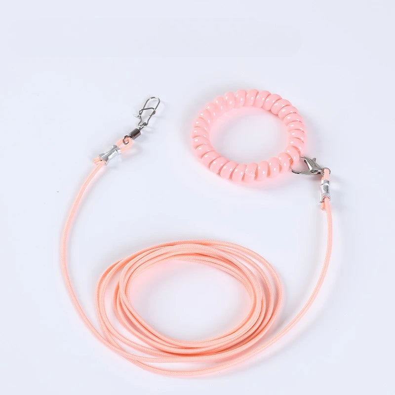 A pink silicone outdoor training harness for parrots is shown coiled and looped.