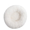 A round, fluffy white plush pet bed for dogs and cats.