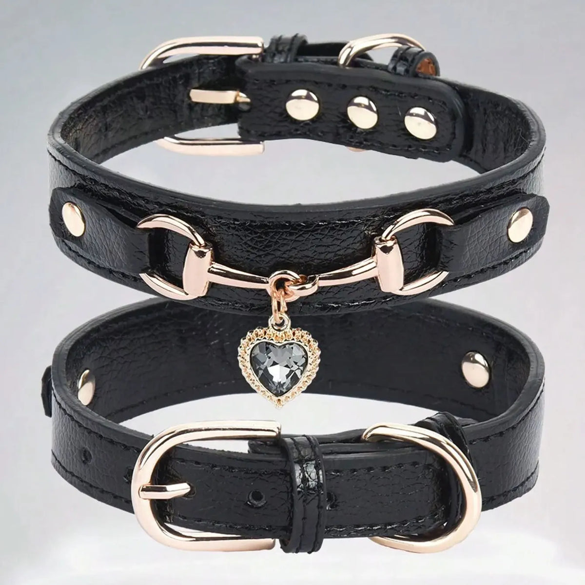A black PU leather dog collar with gold hardware and a heart-shaped gemstone pendant.