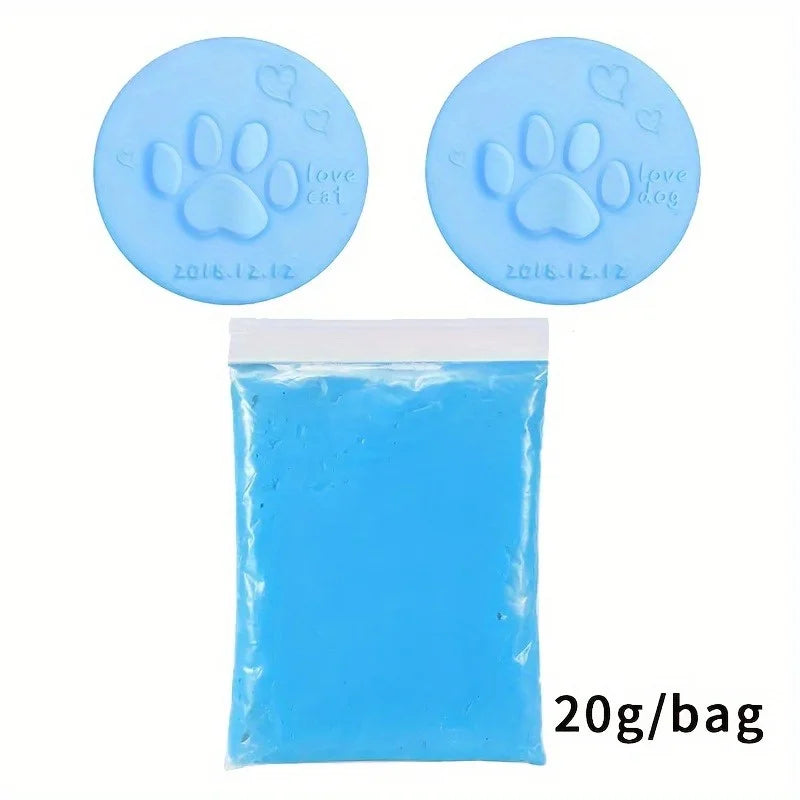 A package containing blue clay and two silicone paw print keepsake molds with dates on them.