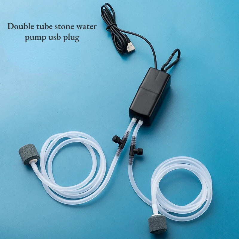 مضخة مياه حجرية ذات أنبوب مزدوجة مع قابس USB وخرطوم، معروضة على خلفية زرقاء.